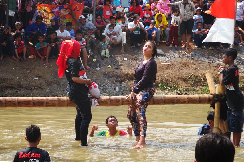 Dua Perempuan Sedang Lomba Pukul Guling